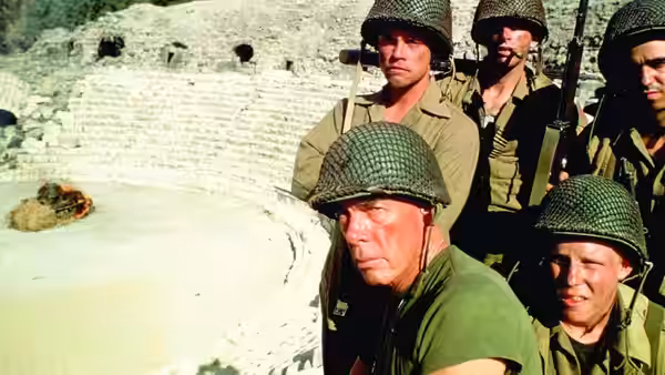 The Sergeant (Lee Marvin) and soldiers look across a ruined stone amphitheater