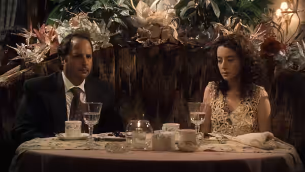 Andy Kornbluth (Jon Lovitz) dining with a woman at a restaurant table