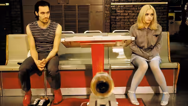 Billy Brown (Vincent Gallo) and Layla (Christina Ricci) sit on a bench in a bowling alley