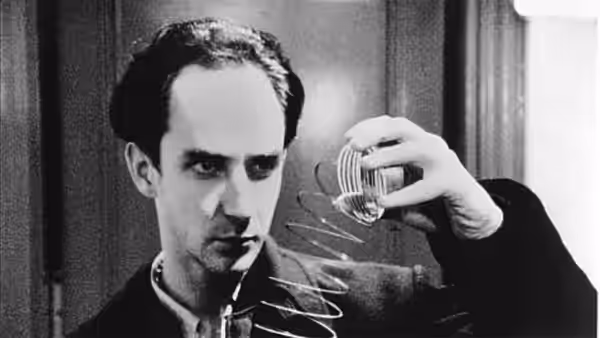 Maximillian Cohen (Sean Gullette) examines a glass and coiled spring