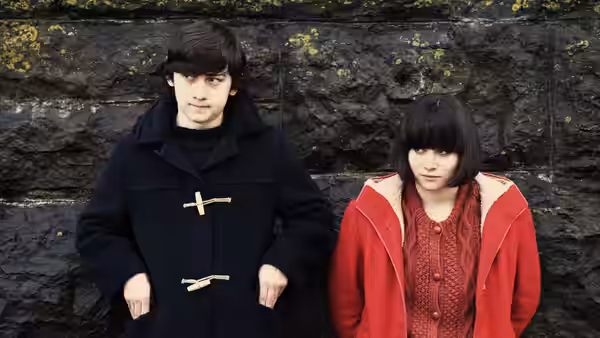 Oliver Tate (Craig Roberts) and Jordana Bevan (Yasmin Paige) stand together against a stone wall