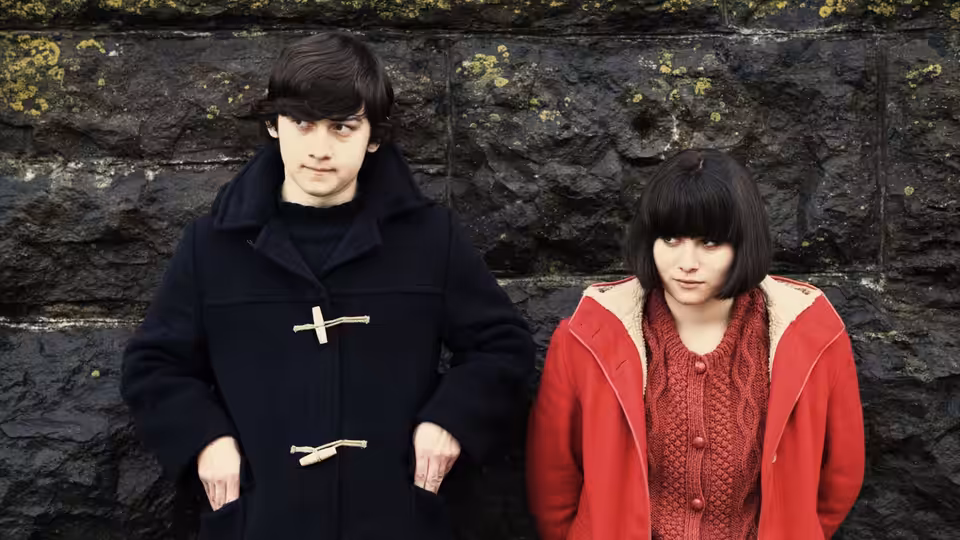 Oliver Tate (Craig Roberts) and Jordana Bevan (Yasmin Paige) stand together against a stone wall