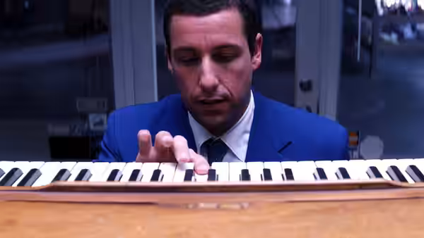 Barry Egan (Adam Sandler) seated at a piano playing the keys intently