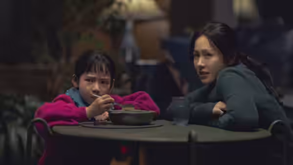 Mi-ri (Son Ye-jin) watching a girl eat at a round table indoors