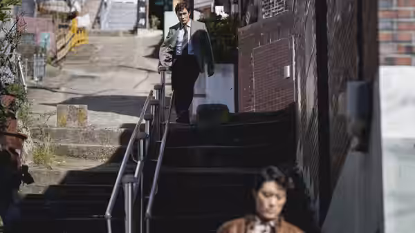 a man in a suit walking down outdoor concrete stairs in daylight