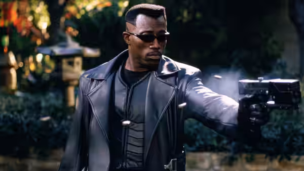 Blade (Wesley Snipes) firing a gun in a garden at night