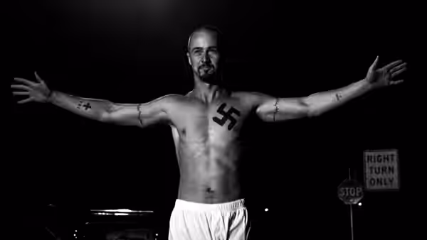 Derek (Edward Norton) standing shirtless with arms outstretched at night