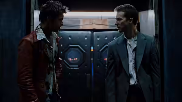 Tyler Durden (Brad Pitt) and Narrator (Edward Norton) standing face to face indoors