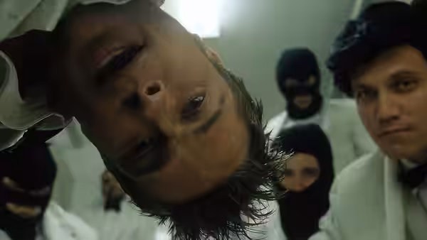 Narrator (Edward Norton) hanging upside down surrounded by masked people in white