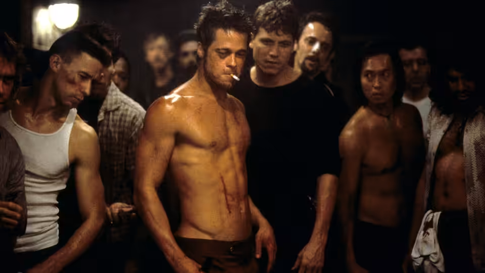 Tyler Durden (Brad Pitt) standing shirtless among a group of men