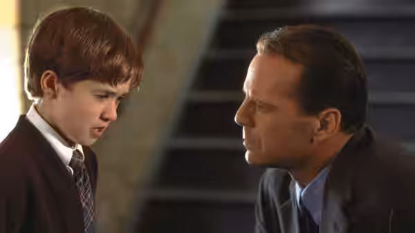Cole Sear (Haley Joel Osment) facing Malcolm Crowe (Bruce Willis) by a staircase