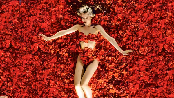 Angela Hayes (Mena Suvari) lying amid red rose petals with arms outstretched