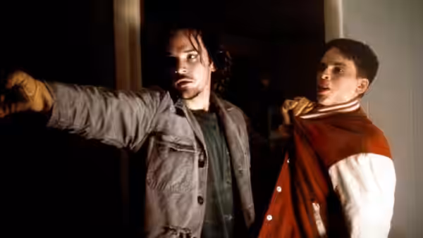 John Lotter (Peter Sarsgaard) pointing while holding Brandon (Hilary Swank) by the neck