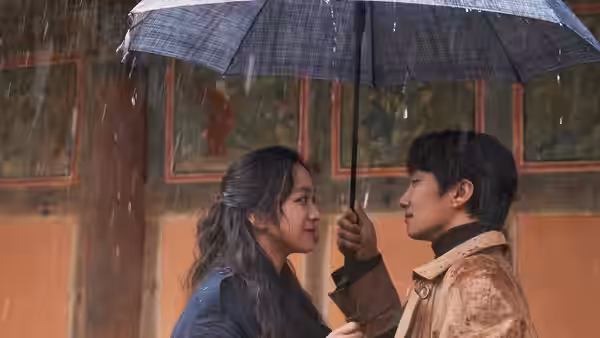 Jang Hae-joon (Park Hae-il) holds an umbrella over Song Seo-rae (Tang Wei) in the rain