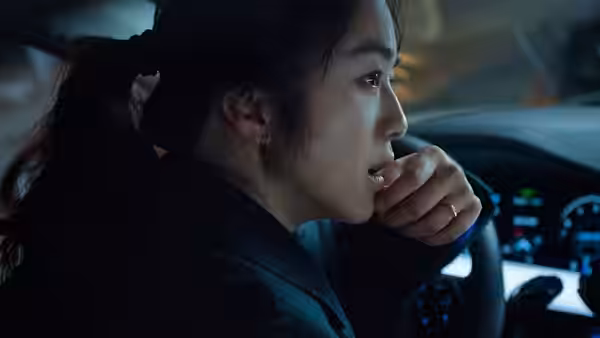 Song Seo-rae (Tang Wei) sits in a car, holding a hand near her mouth