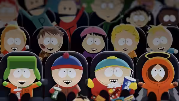 Children in theater seats holding snacks and smiling forward
