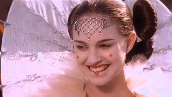 Padmé Amidala (Natalie Portman) smiling in an ornate white gown