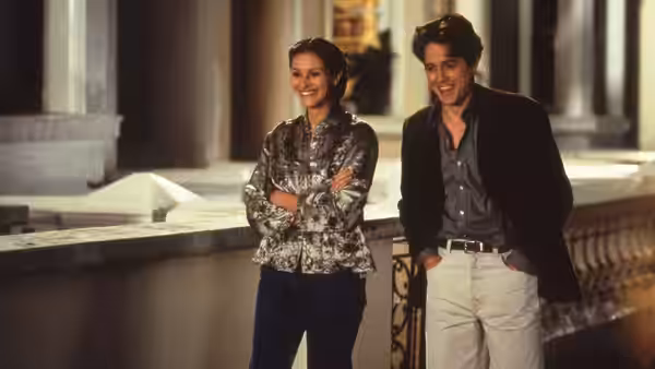 Anna Scott (Julia Roberts) and William Thacker (Hugh Grant) stand on a balcony