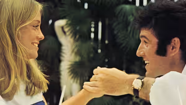 Kelly Corcoran (Cybill Shepherd) and Lenny Cantrow (Charles Grodin) smile as he holds her hand