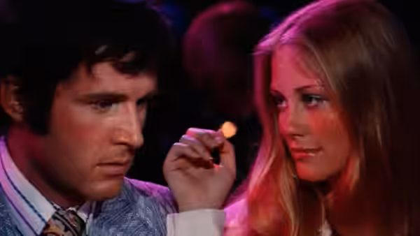 Lenny Cantrow (Charles Grodin) and Kelly Corcoran (Cybill Shepherd) sit together under colored lights