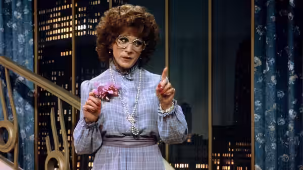 Dorothy Michaels (Dustin Hoffman) holding a flower and pointing on a balcony
