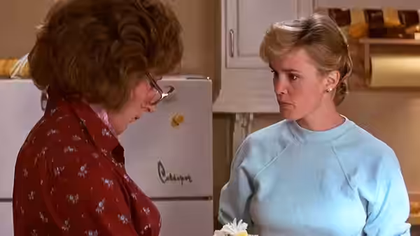 Dorothy Michaels (Dustin Hoffman) speaking with a woman in a kitchen