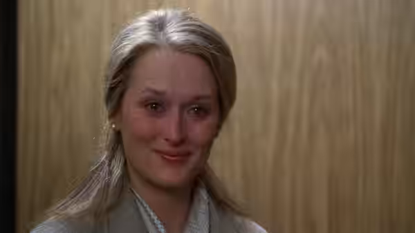 Joanna Kramer (Meryl Streep) with a sad expression against a wooden wall