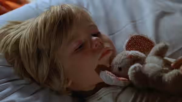 Billy Kramer (Justin Henry) asleep in bed beside a stuffed mouse toy