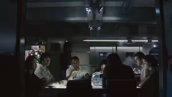 Crew seated around a table in the ship's meeting room