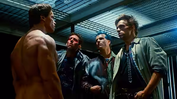 Terminator (Arnold Schwarzenegger) confronting three men in a metal corridor