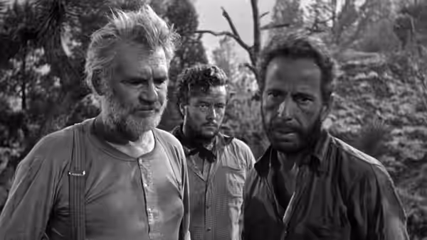 Howard (Walter Huston), Bob Curtin (Tim Holt) and Fred C. Dobbs (Humphrey Bogart) standing together outdoors