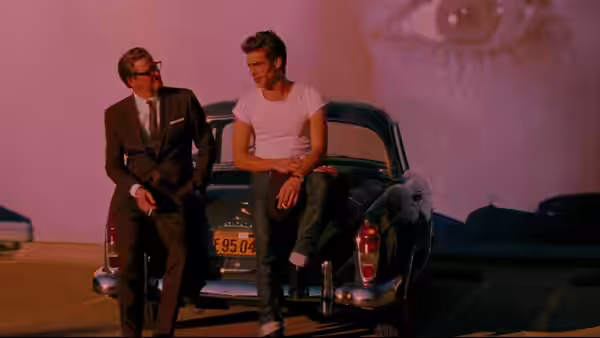 George (Colin Firth) and Carlos (Jon Kortajarena) sit on the back of a parked car