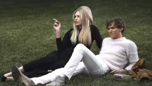 Charley (Julianne Moore) and George (Colin Firth) sit together on the grass, smoking
