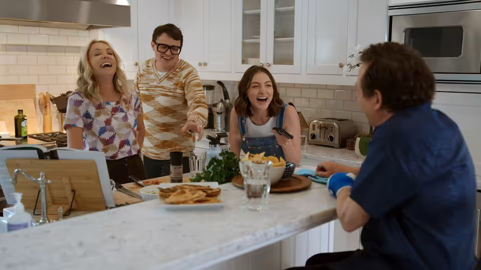 Michael J. Fox (Michael J. Fox) sits at a kitchen island as family members laugh together