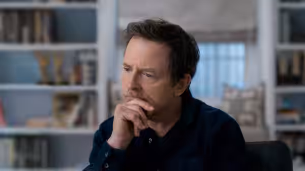 Michael J. Fox (Michael J. Fox) rests his chin on his hand in a home office
