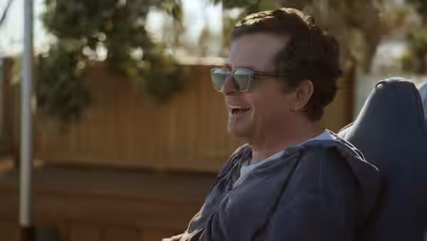 Michael J. Fox (Michael J. Fox) laughs while reclining outdoors in a chair