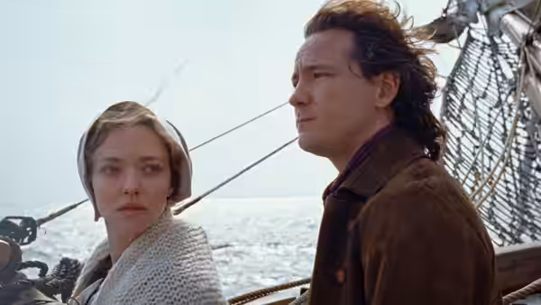 A woman and a man standing on the deck of a ship at sea