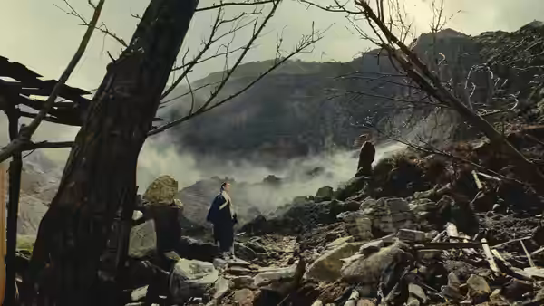 Two figures face each other among rocky ruins beneath bare branches