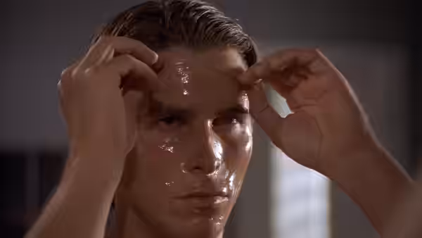 Patrick Bateman (Christian Bale) rubbing skincare into his wet forehead
