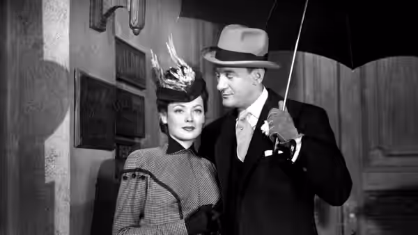 Lucy Muir (Gene Tierney) walks beneath an umbrella beside Miles Fairley (George Sanders)