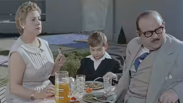 Monsieur and Madame Arpel sit with their son at the dining table