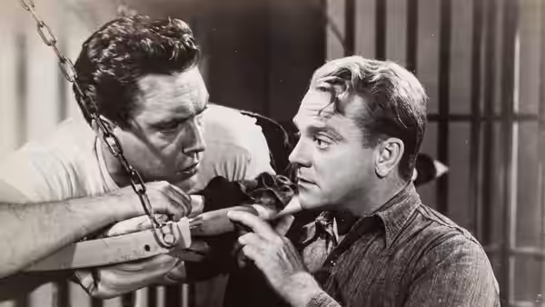 Two men lean close together beside a wooden rail and hanging chain