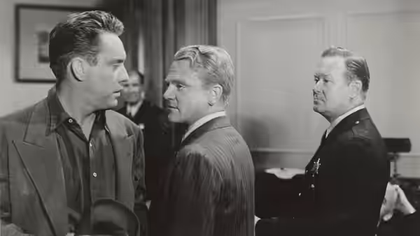 Cody Jarrett (James Cagney) faces two men in a room