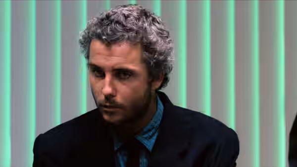 Will Graham (William Petersen) seated and looking to the side against green vertical lights