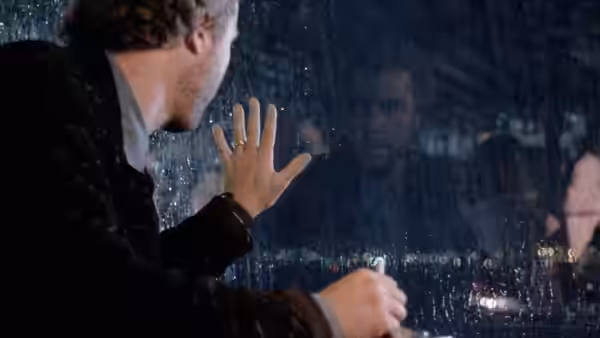 Will Graham (William Petersen) pressing a hand against a rain-streaked window at night