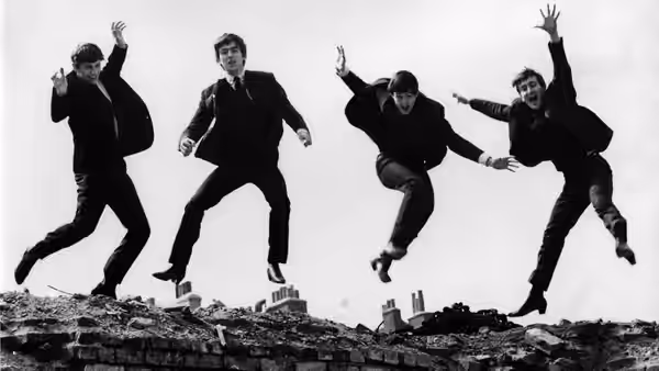 The Beatles leap above a city skyline