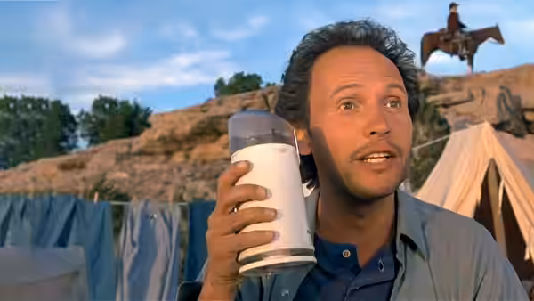 Mitch Robbins holding a blender with a rider on horseback behind him