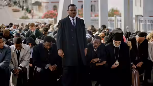 Dr. Martin Luther King Jr. (David Oyelowo) standing among seated men and women outdoors