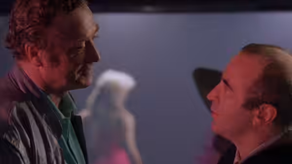 George (Bob Hoskins) facing Mortwell (Michael Caine) in a dark room