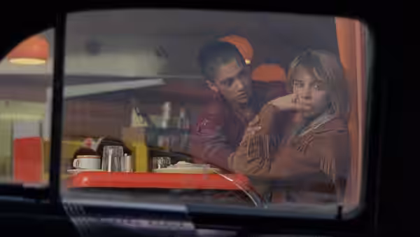 Simone (Cathy Tyson) beside another woman inside a diner seen through the window